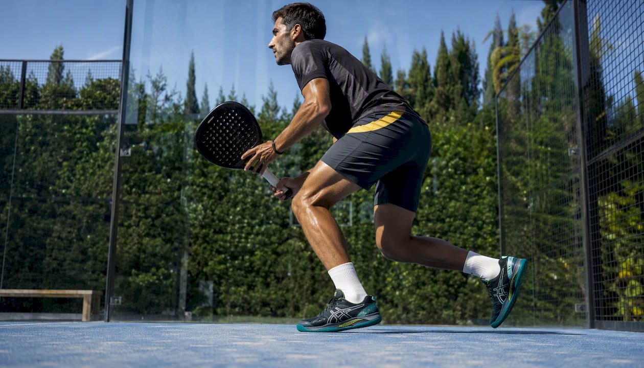Male padel player wearing stable ASICS shoes in action