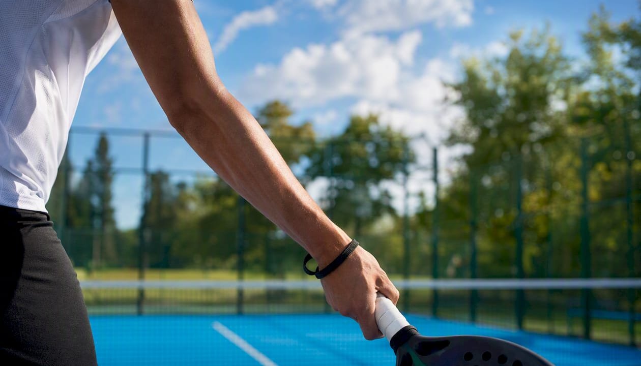 Player practicing underarm padel serve technique