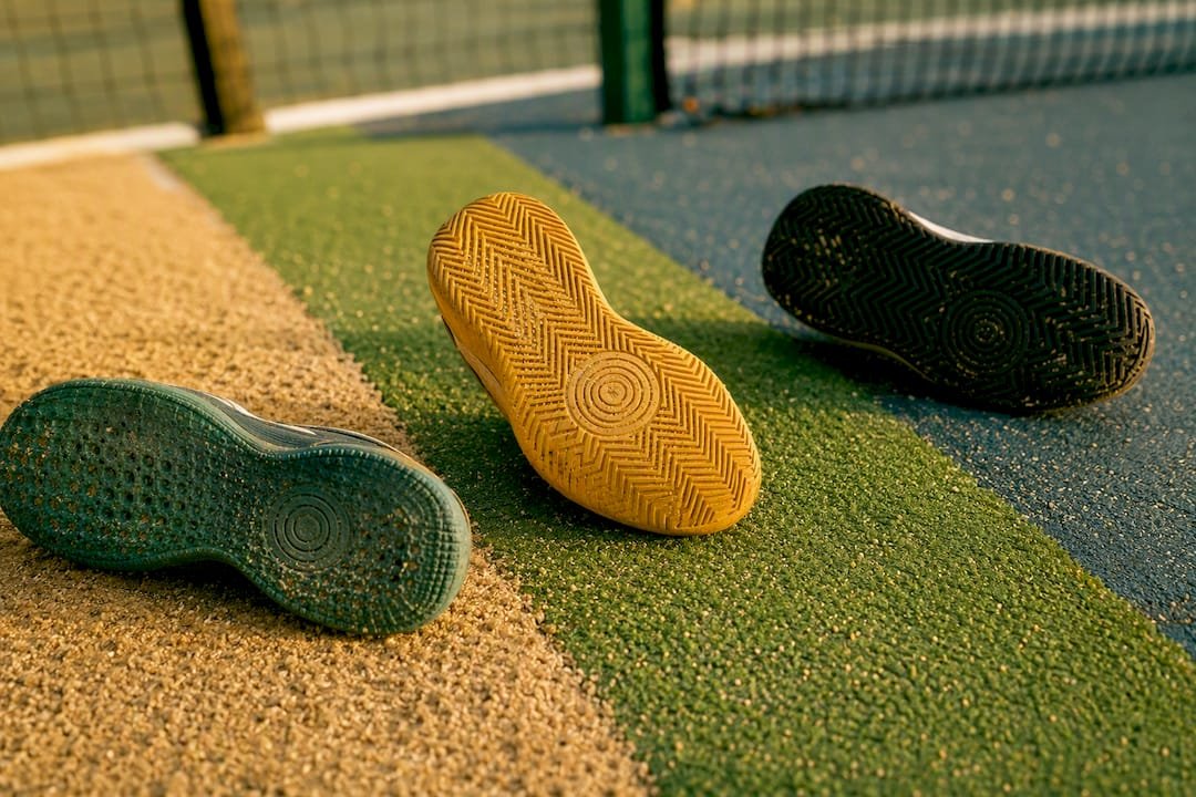 Close-up of padel shoe soles on various court surfaces