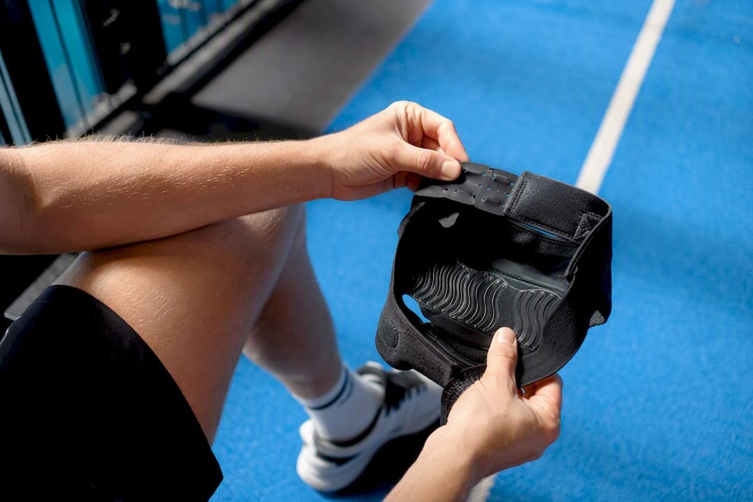 Hands inspecting knee brace strap condition