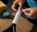 Hands wrapping an overgrip on racket handle